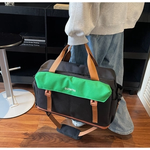 Detail of canvas travel bag featuring green flap cover and sturdy brown buckle straps