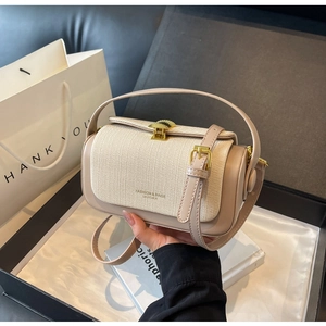 Dettaglio della borsa beige in pelle e tessuto intrecciato con chiusura dorata