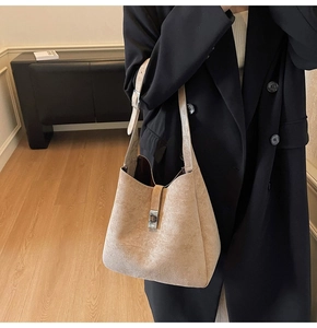 Detail of a beige matte leather hobo bag with silver buckle and adjustable shoulder strap