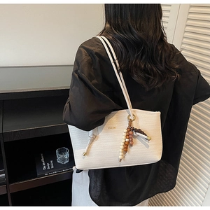 Detailed woven texture of a white tote bag featuring ethnic colorful wooden beads