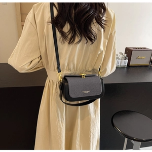 Dettaglio di borsa a tracolla vintage con fibbia dorata indossata da una modella
