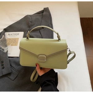 Detail of light green PU leather handbag featuring V-shape stitching and metal lock buckle