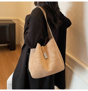 Detail of light brown suede tote bag featuring a vertical silver metallic buckle closure
