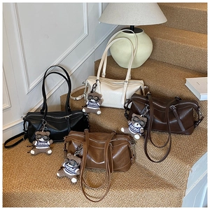 Gruppo di quattro borse Boston vintage in nero, beige e marrone con ciondoli a forma di orso