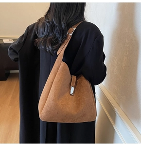 Detail of caramel suede hobo bag with adjustable wide strap and silver metal buckle