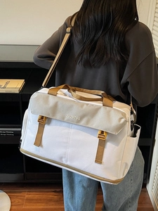 Large capacity white and khaki travel duffel bag worn by a model in a modern room