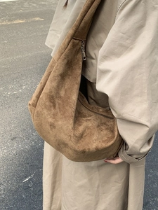 Borsa hobo in finta pelle scamosciata marrone con zip argento indossata da una modella