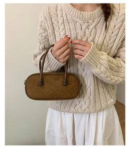 Dettaglio borsa Boston vintage in pelle scamosciata marrone con manici sottili su maglione
