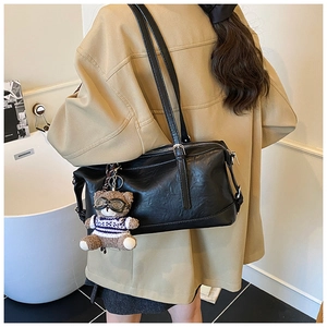 Borsa a spalla retrò in pelle nera con ciondolo a forma di orsetto in interni chic