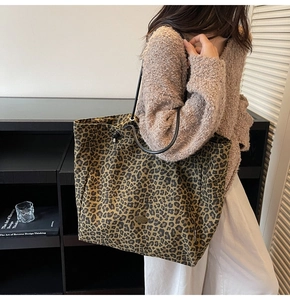 Leopard print canvas tote bag detail on shoulder with minimalist round metal logo plate