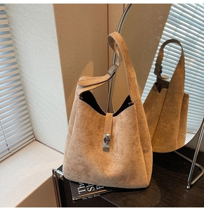 Detail of a brown suede hobo shoulder bag with a silver buckle on a stylish setup
