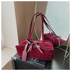 Detailed macro of vintage burgundy suede pillow bag with dual silver zippers and leather pullers