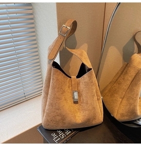 Close-up of brown suede hobo bag featuring adjustable strap and silver metal buckle