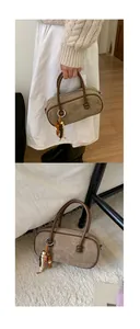 Dettaglio della borsa Boston in camoscio marrone con manici in pelle e ciondoli con perline