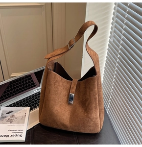 Detailed close-up of brown suede hobo bag featuring silver metallic buckle and strap details