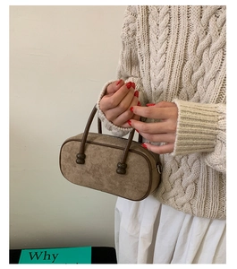 Dettaglio borsa Boston vintage in pelle scamosciata marrone con manici a sfera e zip