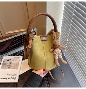 Frosted bucket bag detail with suede texture, brown leather handle and cute rabbit charm