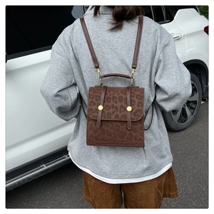 Detail eines Vintage-Rucksacks mit Leopardenmuster, Lederriemen und Pelztextur