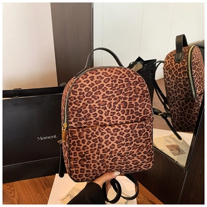 Detailansicht des Rucksacks mit Leopardenmuster, goldenen Reißverschlüssen und schwarzen Trägern