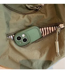 Détail du sac à bandoulière en nylon vert armée avec poche zippée et doublure à rayures