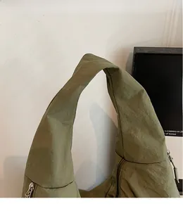 Vue détaillée de l'anse du sac cabas en nylon froissé de couleur vert armée