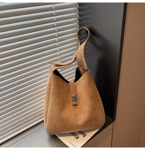 Detail of vintage brown suede shoulder bucket bag with stylish rectangular metal clasp