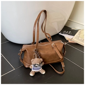 Dettaglio borsa bowling vintage marrone con tracolla e ciondolo orsetto di peluche