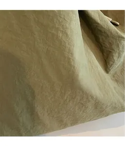 Détail du tissu en nylon vert olive avec texture plissée fine sur le sac à bandoulière