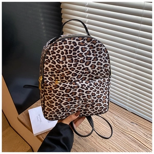 Detailansicht des Leopard-Rucksacks mit schwarzem Lederbesatz und goldenem Reißverschluss