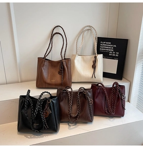 Close-up of five colorful large woven tote bags showing premium textured leather material