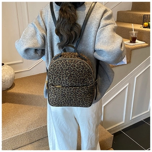 Rückansicht eines modischen Leoparden-Rucksacks mit schwarzen Lederriemen und Gold-Reißverschluss