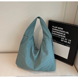Détail d'un grand sac cabas en nylon gris-bleu avec fermetures éclair et texture douce