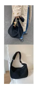 Détail d'un grand sac hobo en daim noir présenté en extérieur et en studio photo