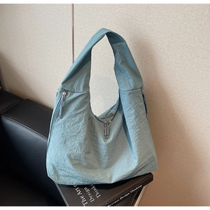 Détails du sac cabas en nylon bleu clair avec poches zippées et texture plissée