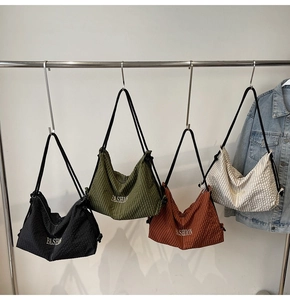 Detail of waffle textured shoulder bags in four colors with FASHION lettering