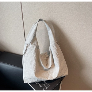 Détail du tissu texturé gris clair et de la fermeture éclair de ce grand sac cabas