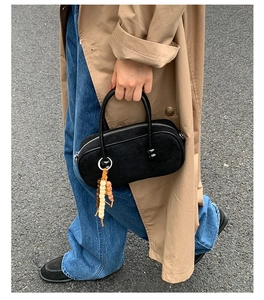 Scatto street style di una borsa bowling scamosciata nera con ciondolo di perline