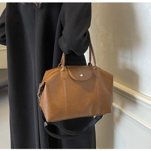 Detail of vintage brown textured leather tote with fashion classic wide shoulder strap