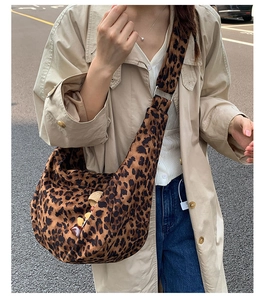 Détail du grand sac bandoulière en croissant à imprimé léopard avec pendentifs
