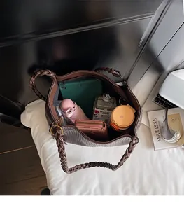 Spacious interior of brown tote bag holding tablet, umbrella and daily essentials
