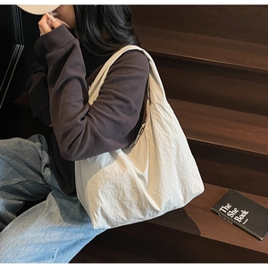 Détail d'un grand sac hobo crème en tissu texturé plissé idéal pour un usage quotidien