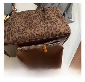Dettaglio della borsa tote leopardata con cinturino in pelle e hardware della cerniera dorata