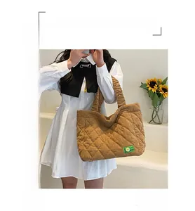 Detail of caramel corduroy tote bag featuring quilted texture and green woven label decor