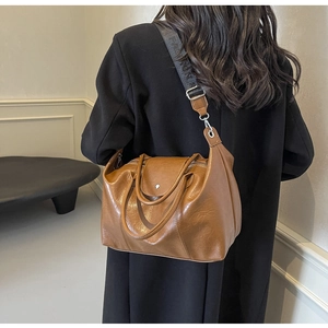 Detail of caramel brown leather tote featuring wide fashion strap and double zipper closure