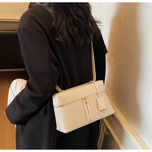 Close-up of beige woven leather shoulder bag styled on model in minimalist interior