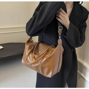 Detail of vintage brown oil wax leather tote bag with stylish wide shoulder strap