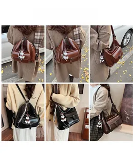 Détail des grands sacs hobo marron et noir avec breloques de chien pour le transport