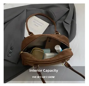 Macro view of the internal capacity and suede texture of this brown Boston bag
