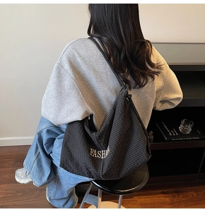 Detailed back view of a checkered tote bag with fashion embroidery on shoulder