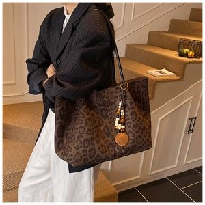 Dettaglio borsa tote leopardata con ciondolo in perline di legno e spalline nere sottili